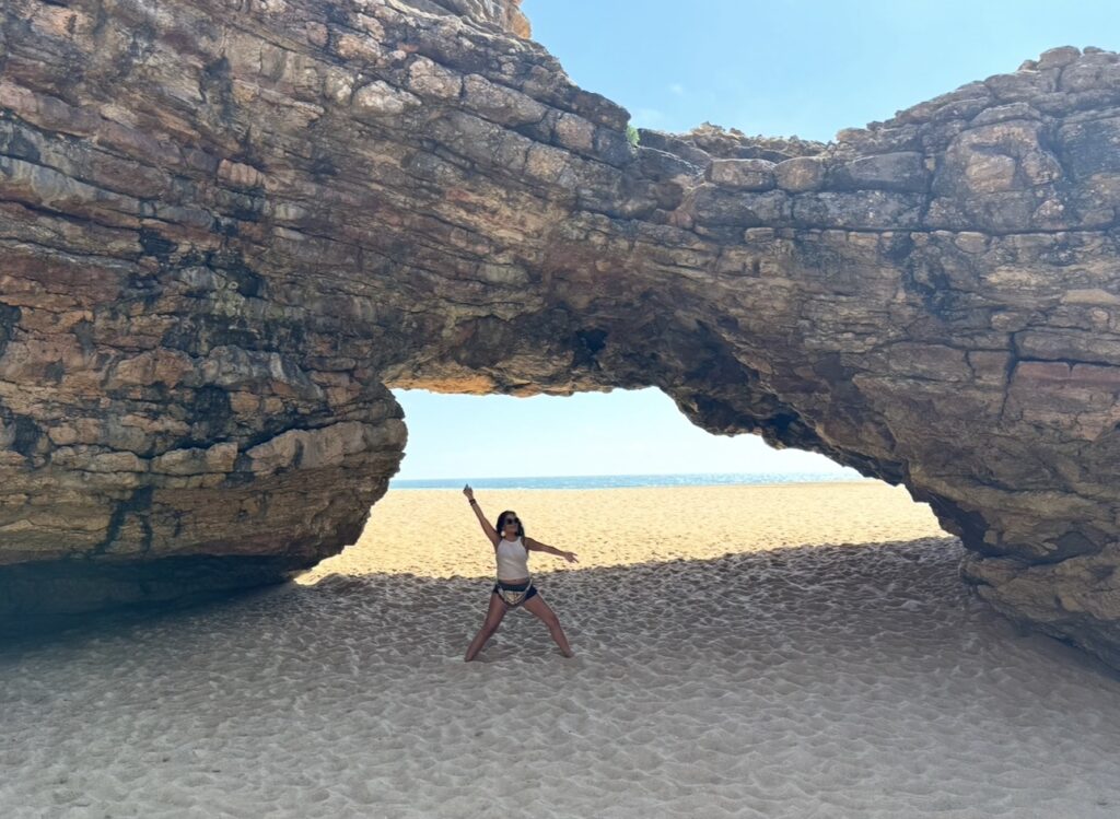 Silvia am Strand unter einem natürlichen Felsbogen